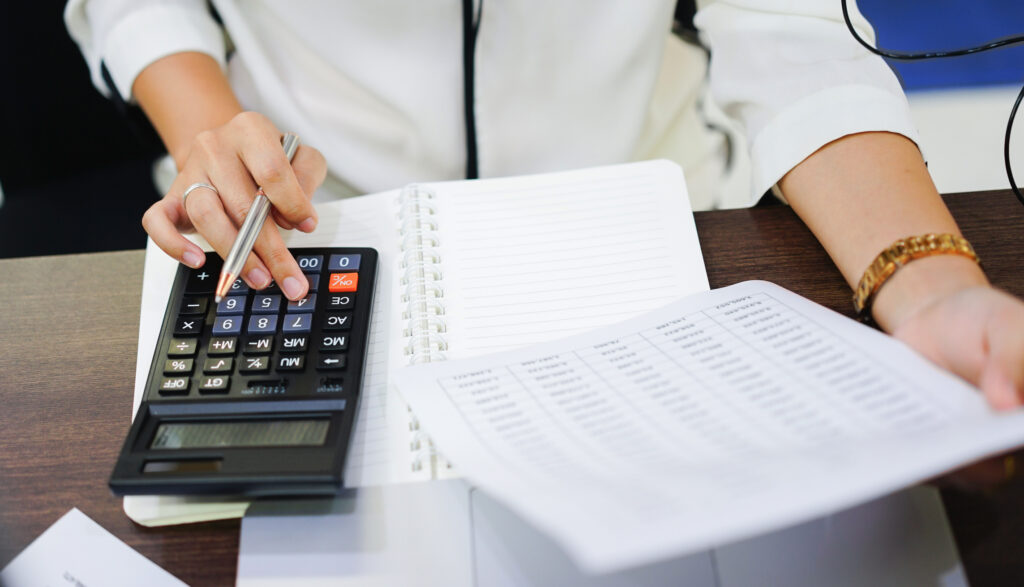 close up on woman hand pressing on calculator for calculating cost estimating , senior accountant job working concept